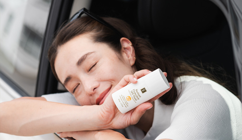 a woman holding the radiant spf protection fluid